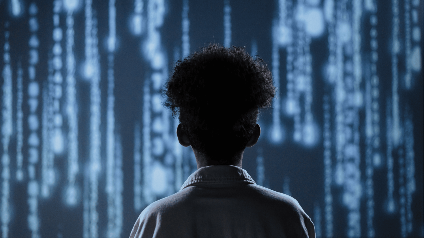 Back of the head of a person standing in front of a wall of moving lights