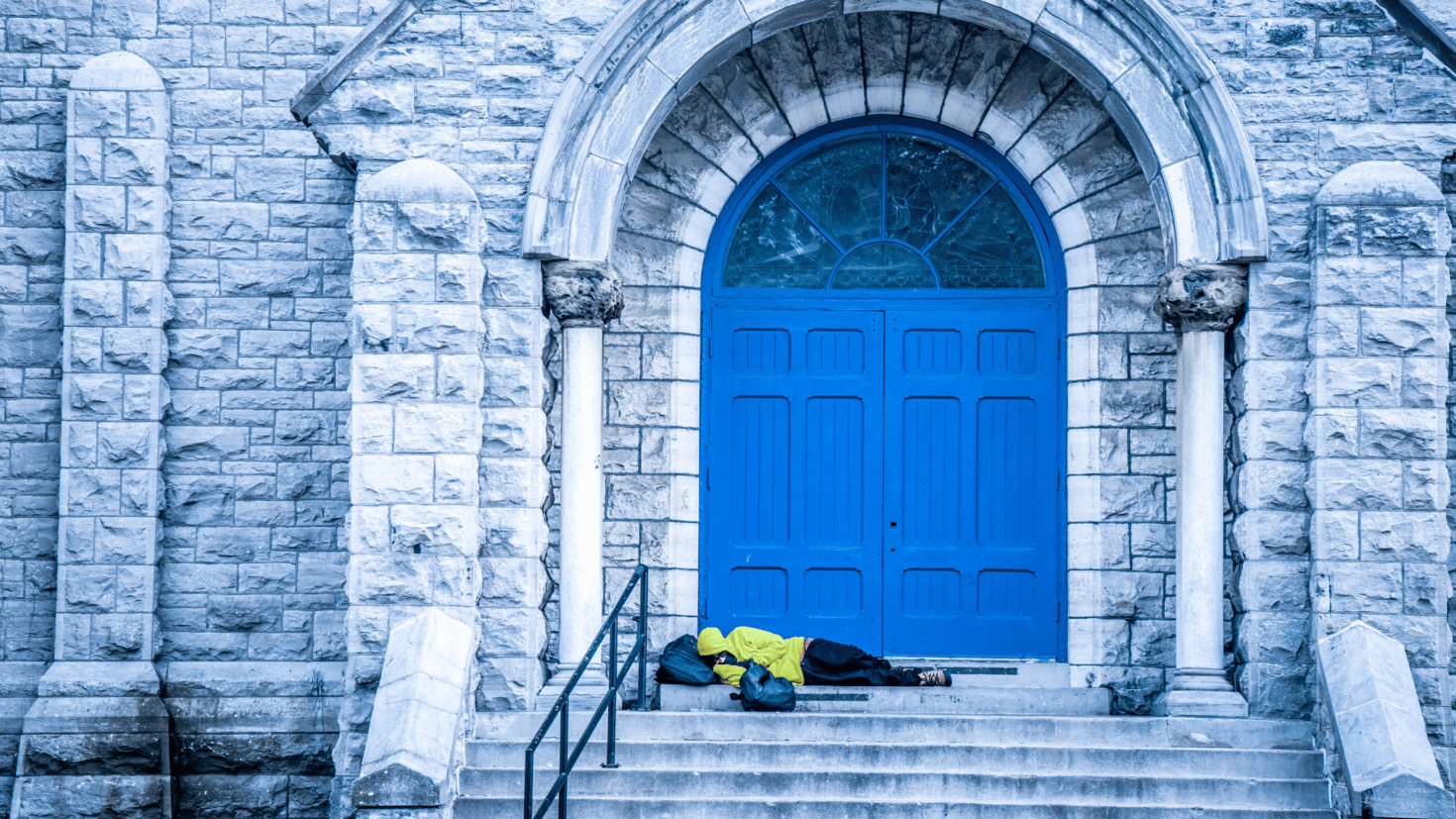 a person sleeping on steps in front of a church door 
