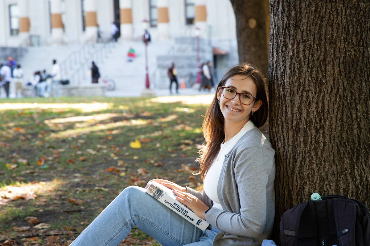 Student studying at the foot of a tree