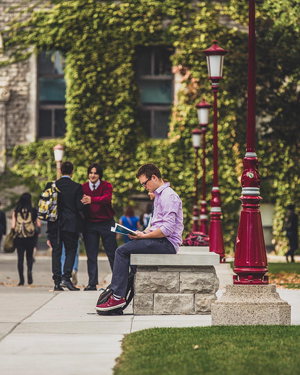 Student reading on campus