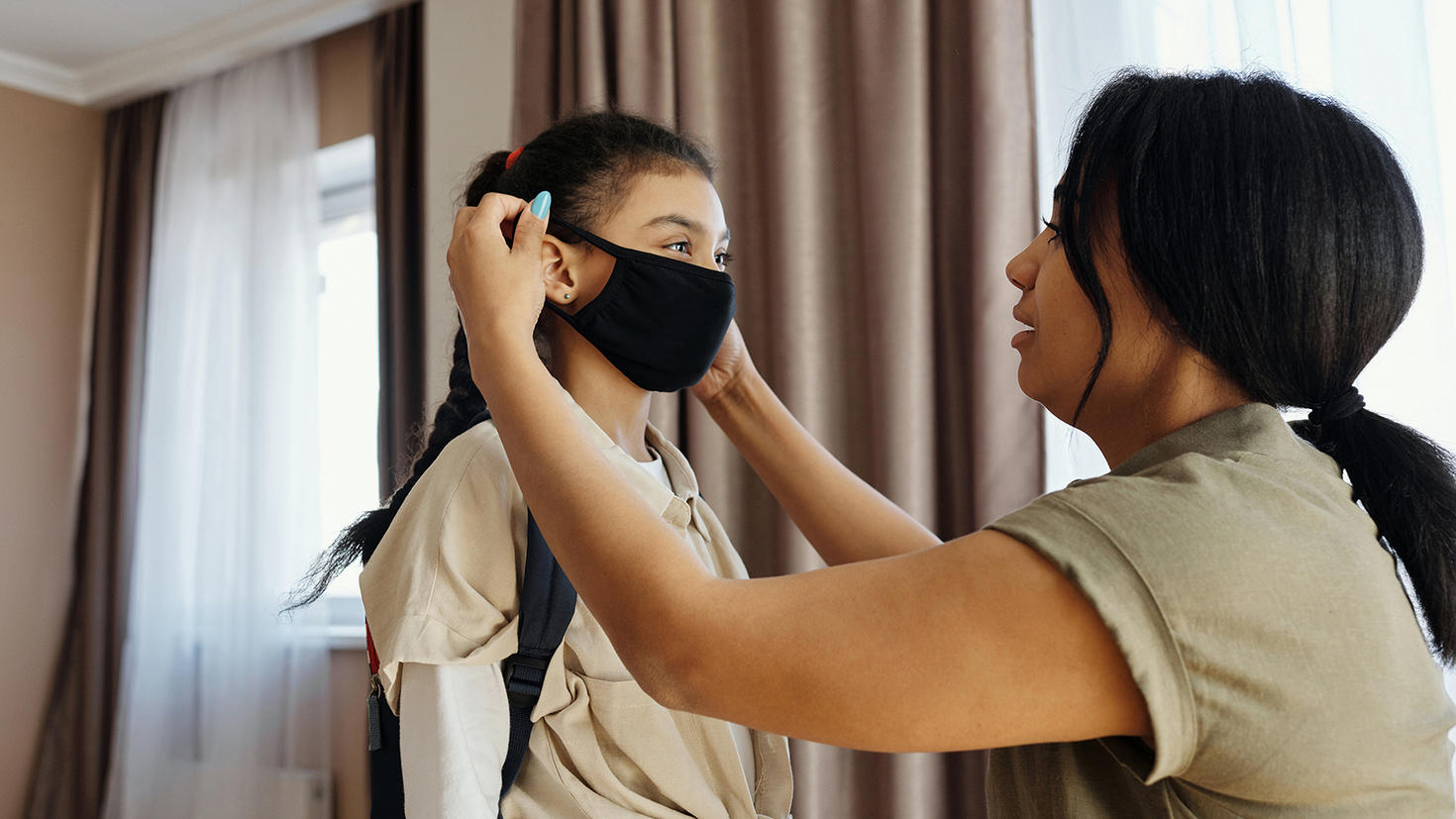 mother putting mask on daughter