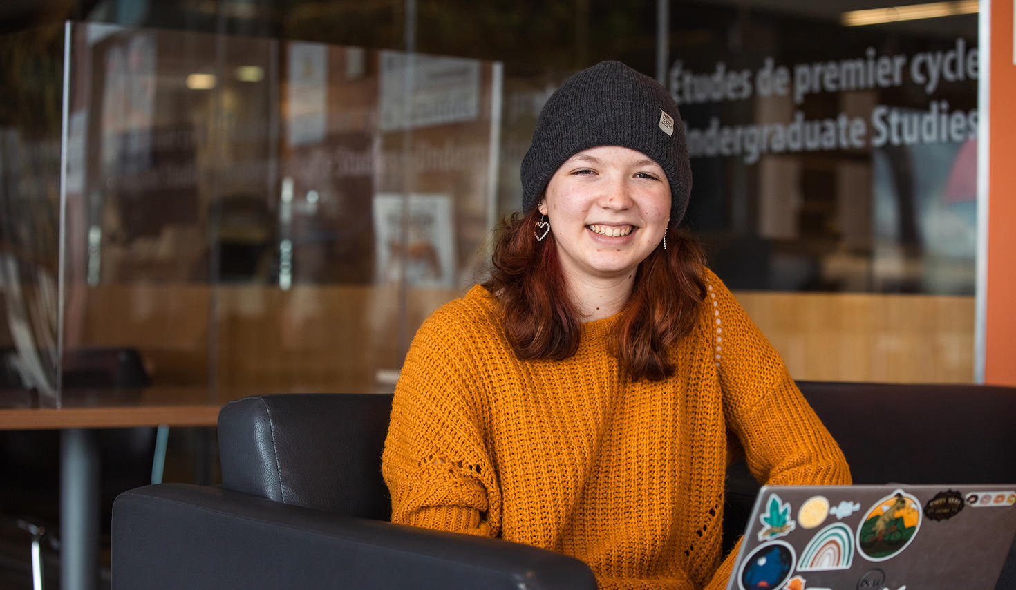 Smiling female student working on a laptop
