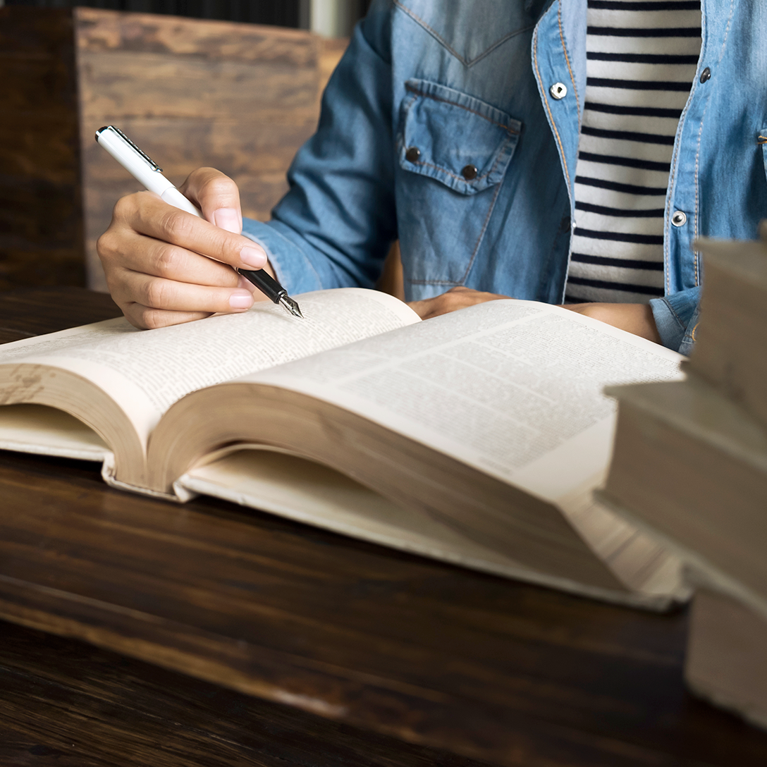 Person writing in book.