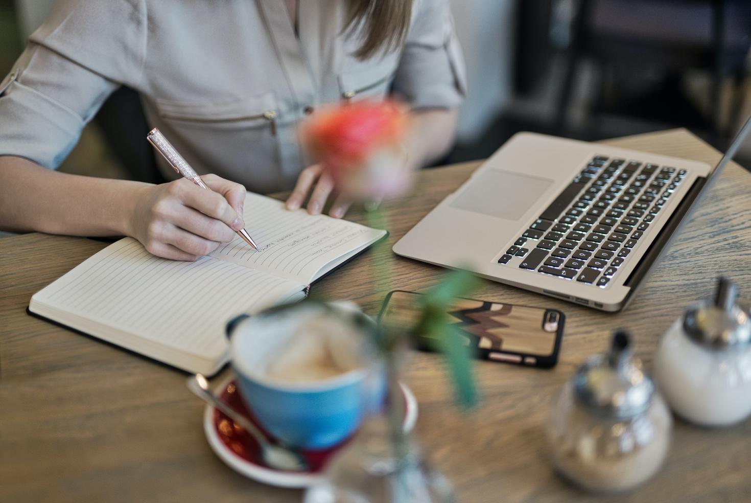 A person working with a laptop and notebook