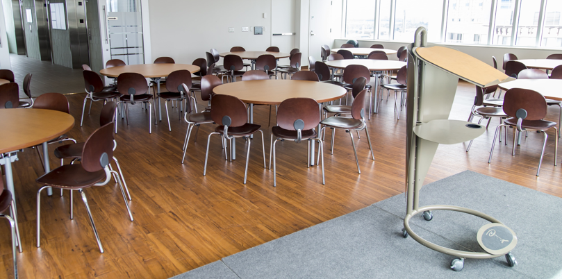 Salle avec tables rondes et podium.