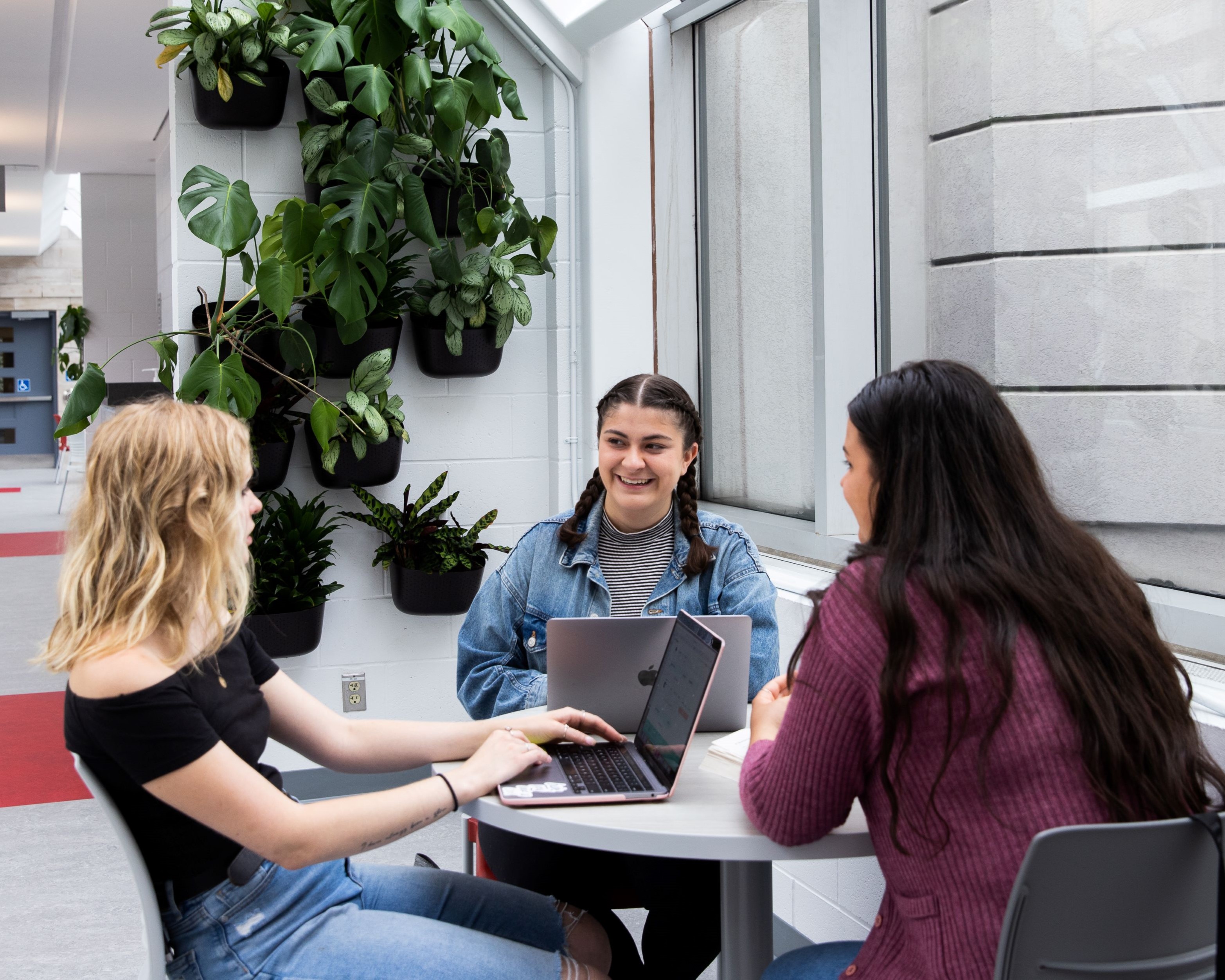 3 étudiantes travaillant ensemble autour d'une table