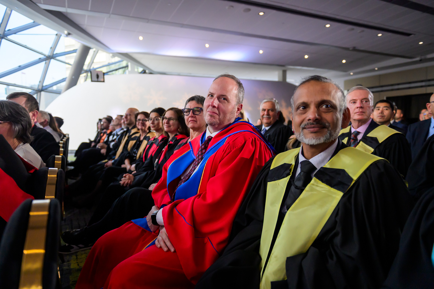 Membres universitaires assis dans la foule lors de la cérémonie d'installation