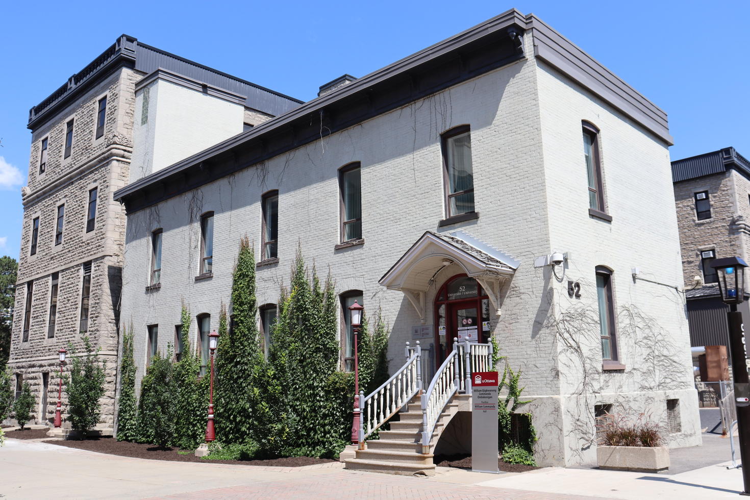 Institut de recherche et d'études autochtones sur le campus de l'Université d'Ottawa. Il s'agit d'un bâtiment en briques blanches dont un côté est partiellement recouvert de vignes.