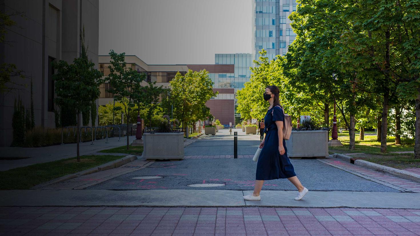 étudiant masqué traversant le campus
