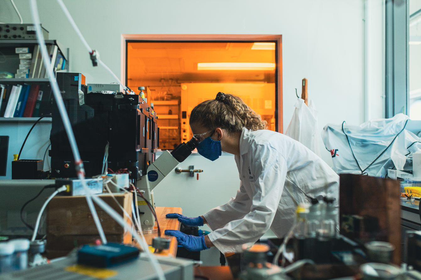 Chercheuse qui travaille sur un microscope