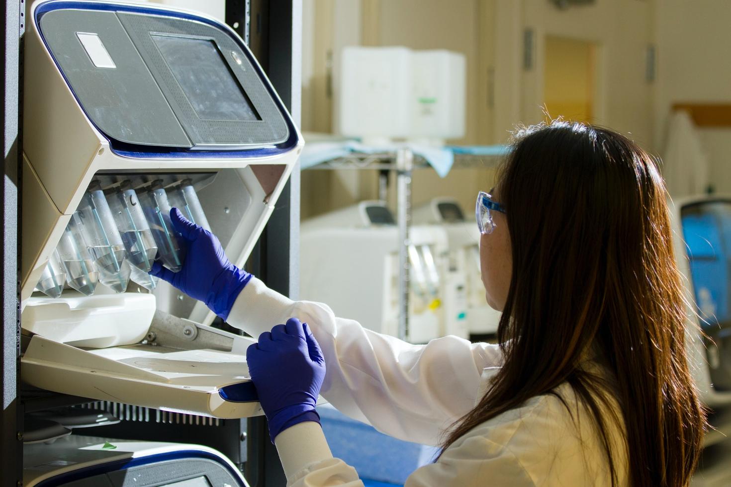 Femme scientifique dans un laboratoire regardant des tubes à essai
