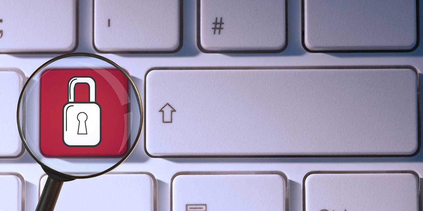  Gros plan d'un clavier avec le symbole du cadenas sur l'une des touches, agrandi par une loupe.
