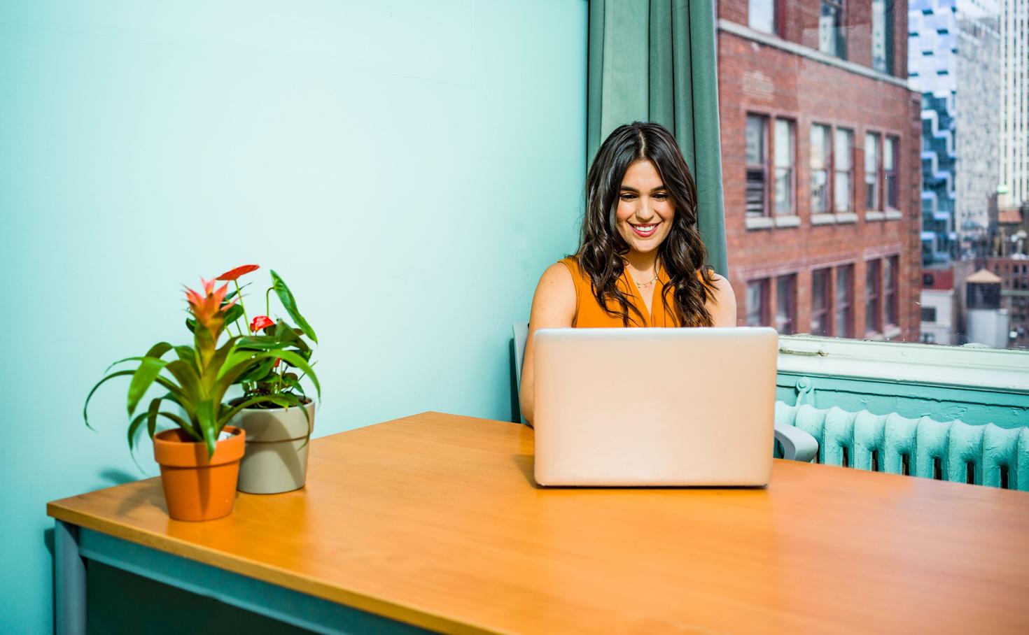  Femme assise à un bureau et travaillant sur un ordinateur portable
