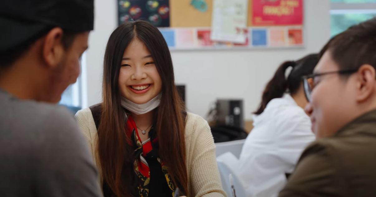Etudiant souriant, travaillant avec d'autres etudiants