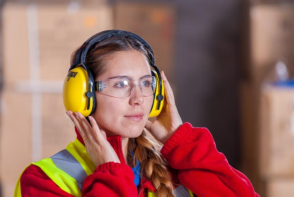 Person with safety ear protection and safety vest.