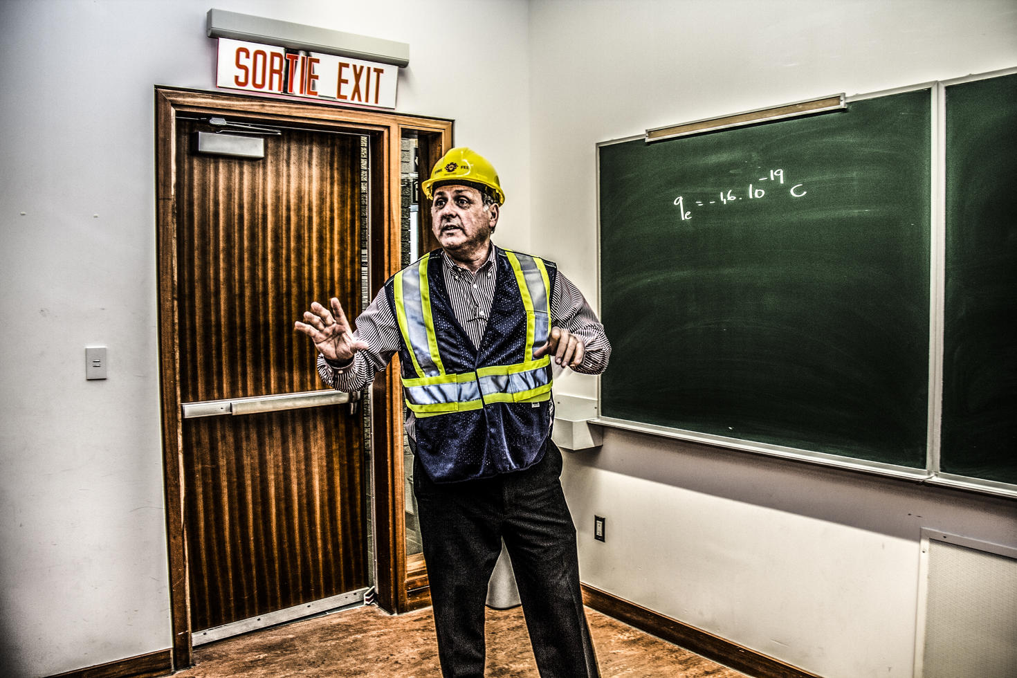 Homme portant un casque jaune dans une salle de classe