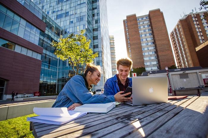Deux étudiants révisent à l'extérieur du Pavillon des sciences sociales.