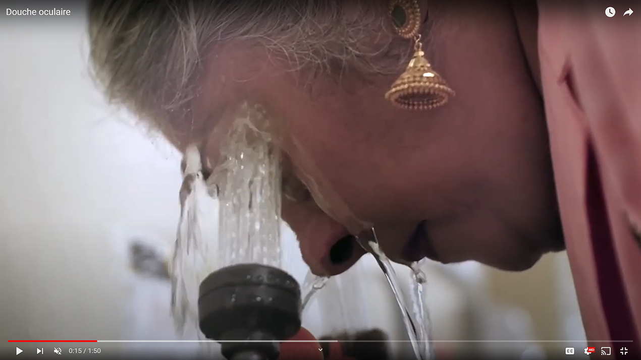 travailleur de laboratoire utilisant la station de lavage des yeux