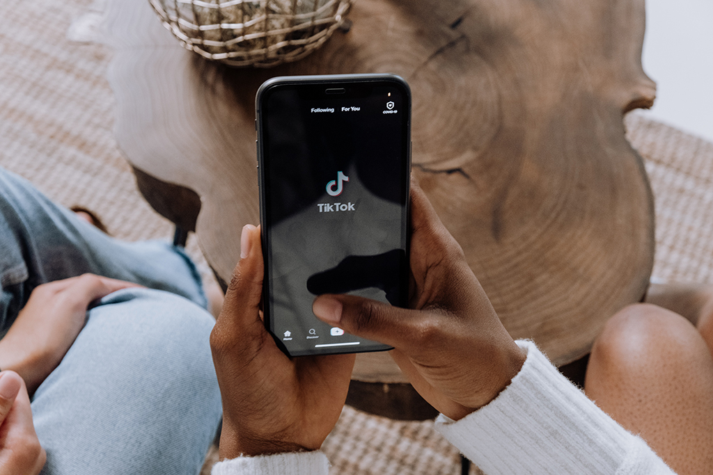 hand on mobile phone with TikTok app open