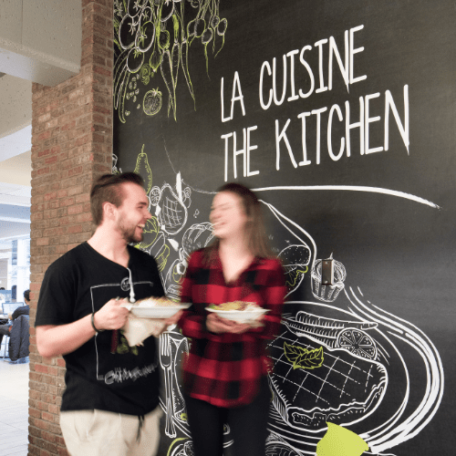 Une cafétéria universitaire avec l'inscription "la cuisine" sur le mur.