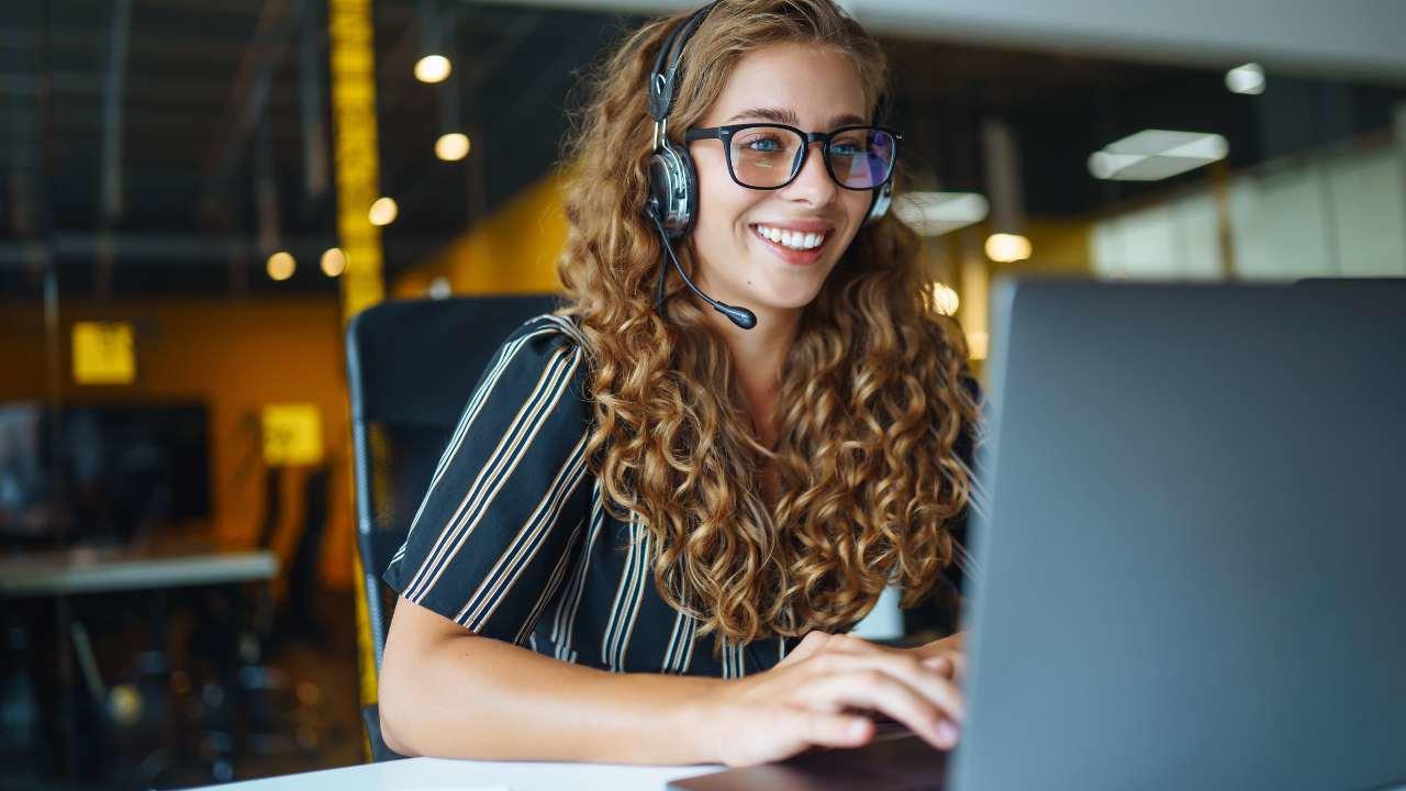 Femme portant un casque audio et utilisant un ordinateur portable 