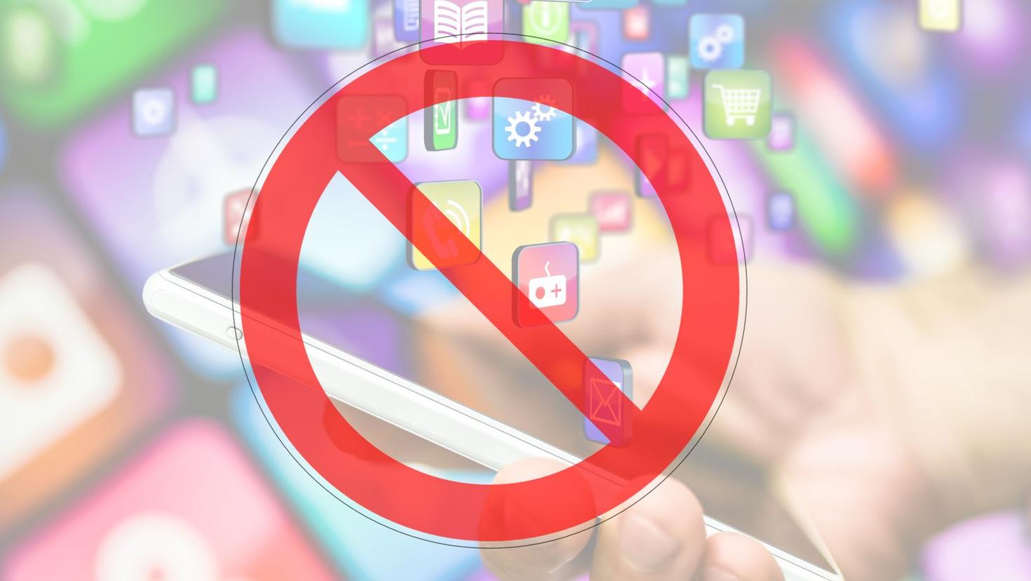 Symbole interdiction en rouge au dessus d'un fond montrant des icônes d'applications émanant d'un téléphone mobile 