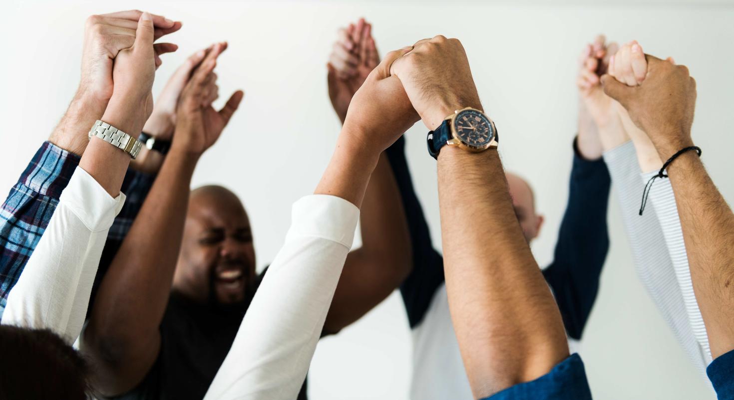 personnes se tenant les mains levées en signe de célébration