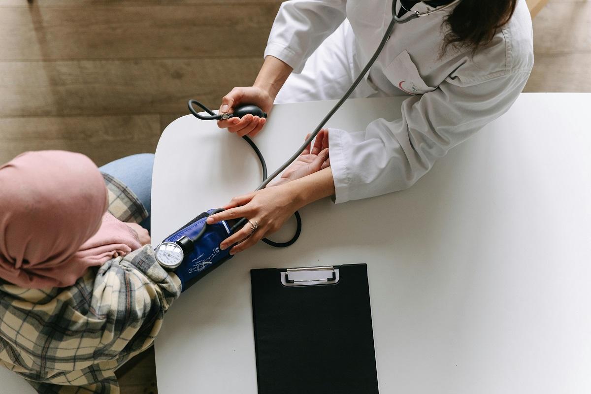 Une femme fait contrôler sa tension artérielle par un médecin
