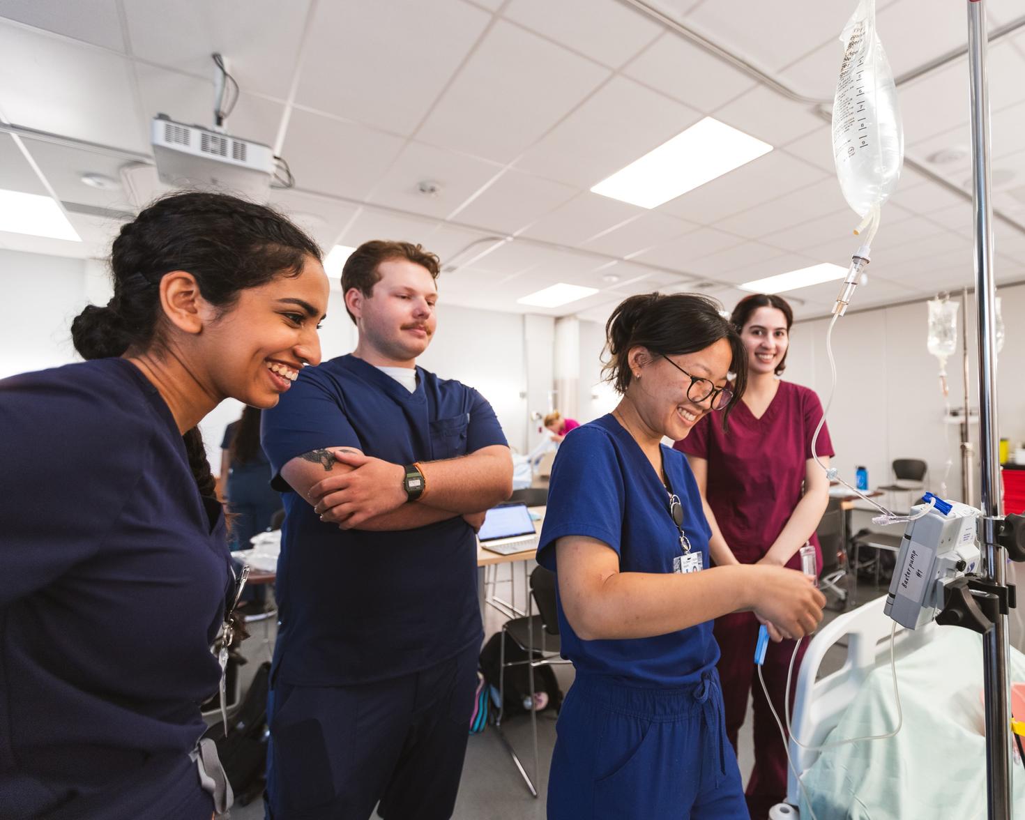4 étudiants en médecine se tenant côte à côte, souriants.