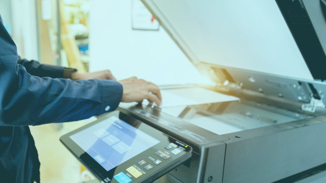 Mains plaçant un papier dans la zone de scan d'une imprimante publiique 