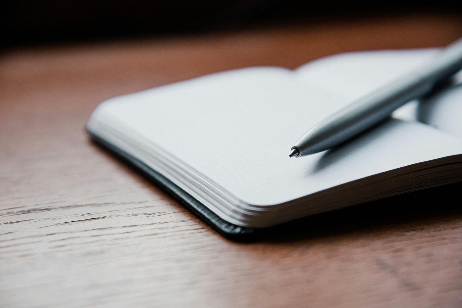un cahier ouvert avec un crayon déposé sur les pages