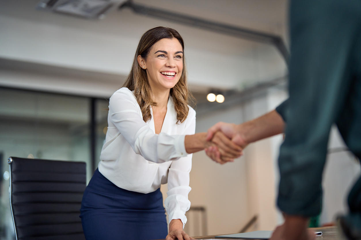 Personne souriant et serrant la main d'une autre personne