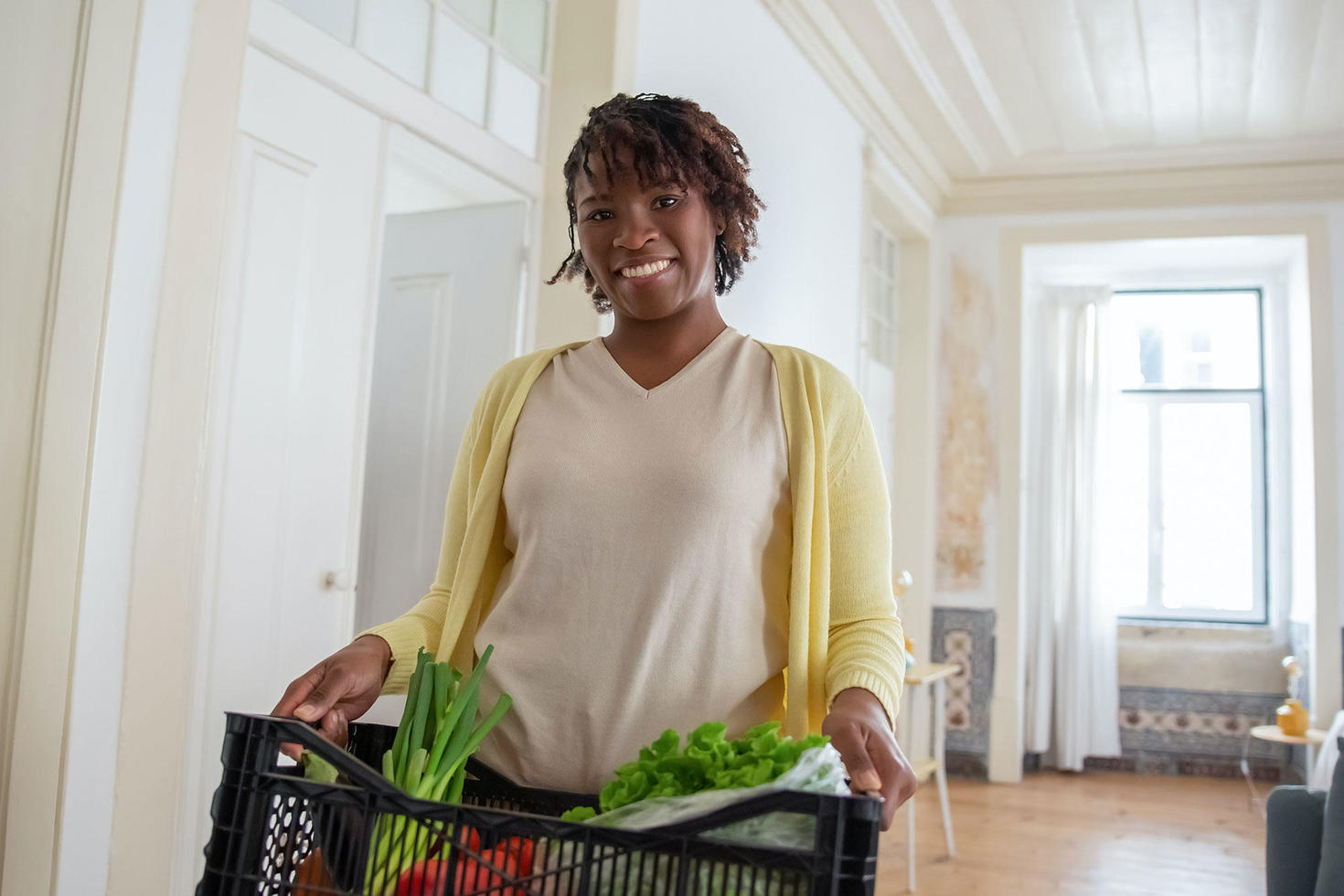 personne portant une boîte de légumes
