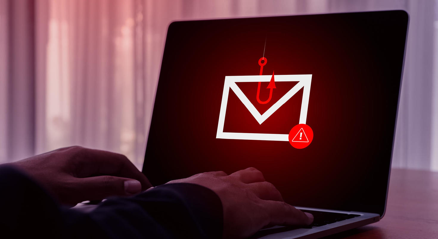 Un écran d'ordinateur portable représentant un hameçon rouge attrapant une enveloppe, qui sert d'avertissement pour mettre en garde contre les tentatives d'hameçonnage.