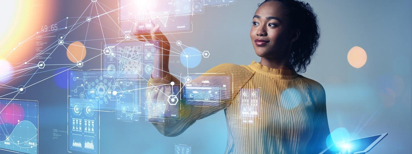 Une femme tient un ordinateur portable affichant une interface numérique, concentrée sur l’écran avec une expression réfléchie.