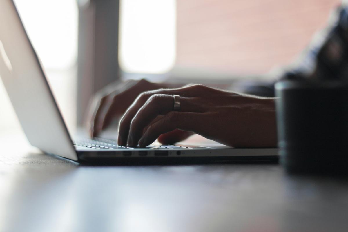Une personne en train de taper sur un ordinateur portable