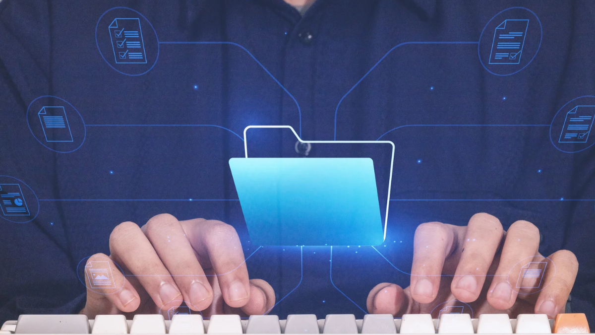 Gros plan de mains en train de taper sur un clavier, avec une icône de dossier numérique lumineuse flottant au-dessus des touches.