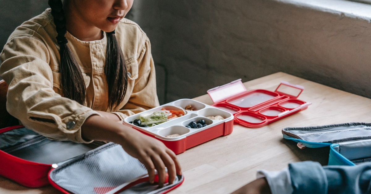 Un enfant qui ouvre sa boîte à lunch