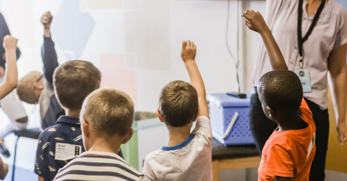 Jeunes élèves posant des questions en classe.