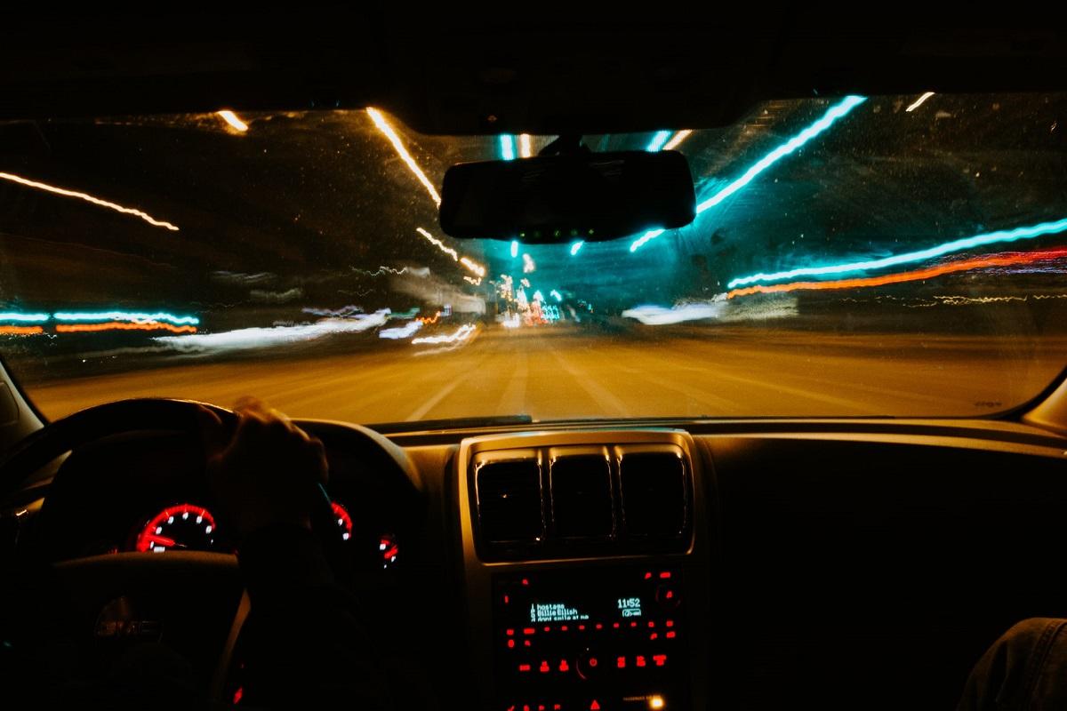 Vue des rues floues de la nuit du point de vue du conducteur d'une voiture