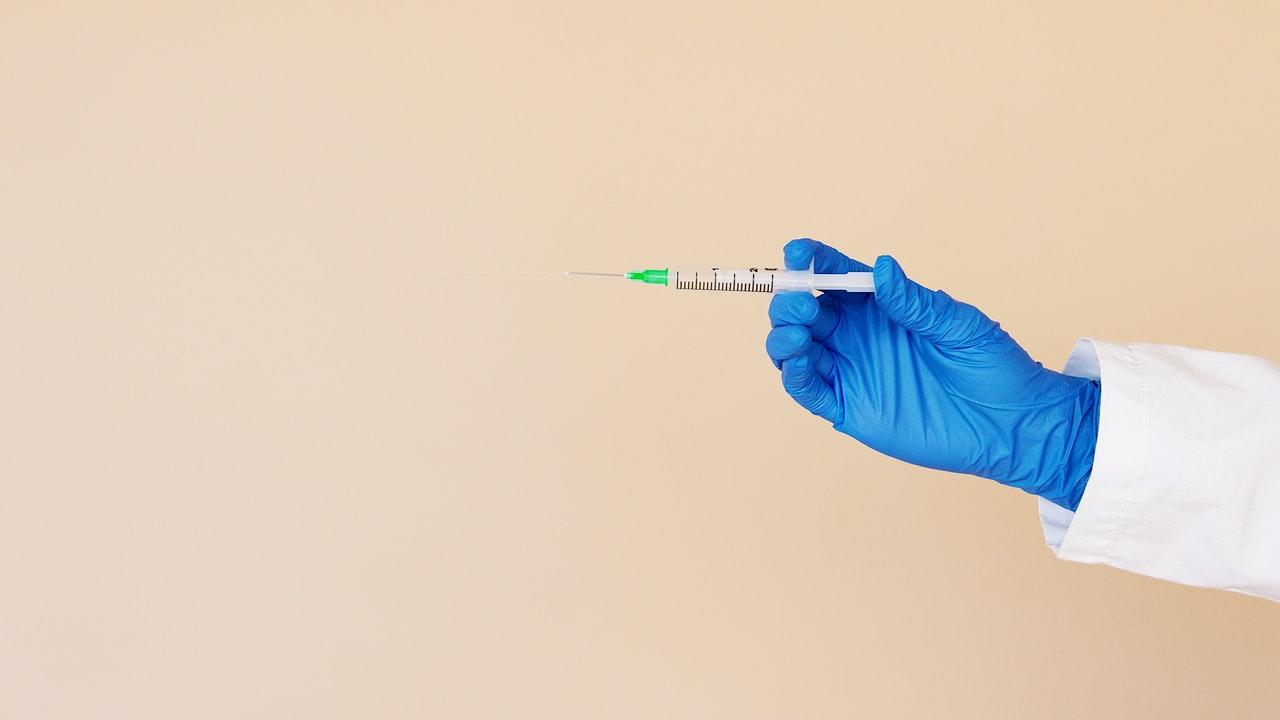 Main gantée médicalement tenant une aiguille