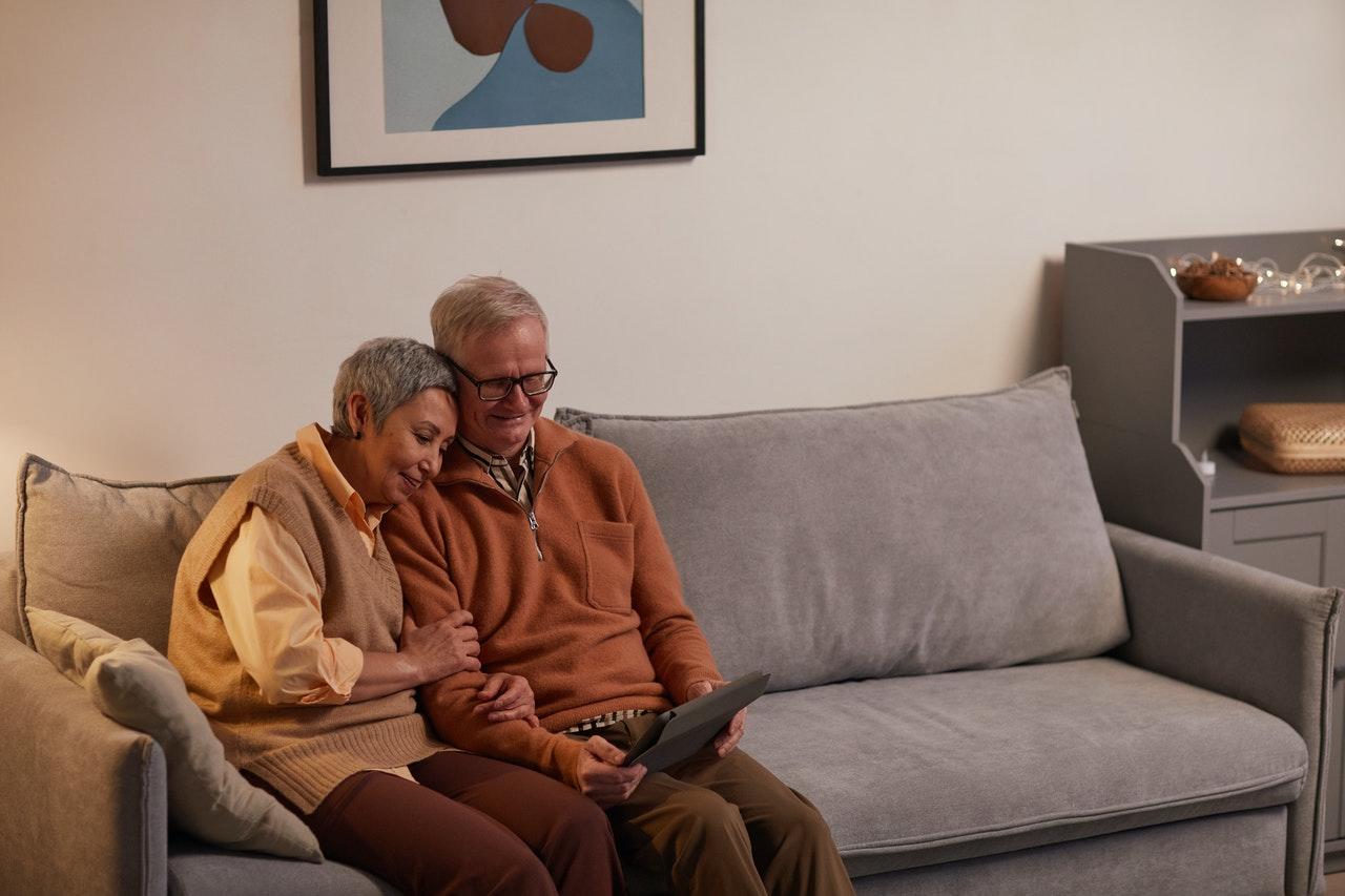 Couple âgé sur un canapé regardant une tablette ensemble
