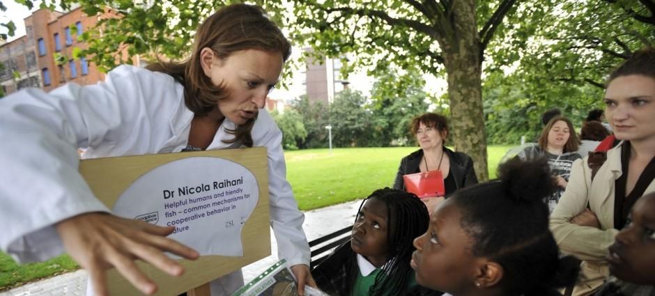 Une femme scientifique fait part d'une expérience à des enfants