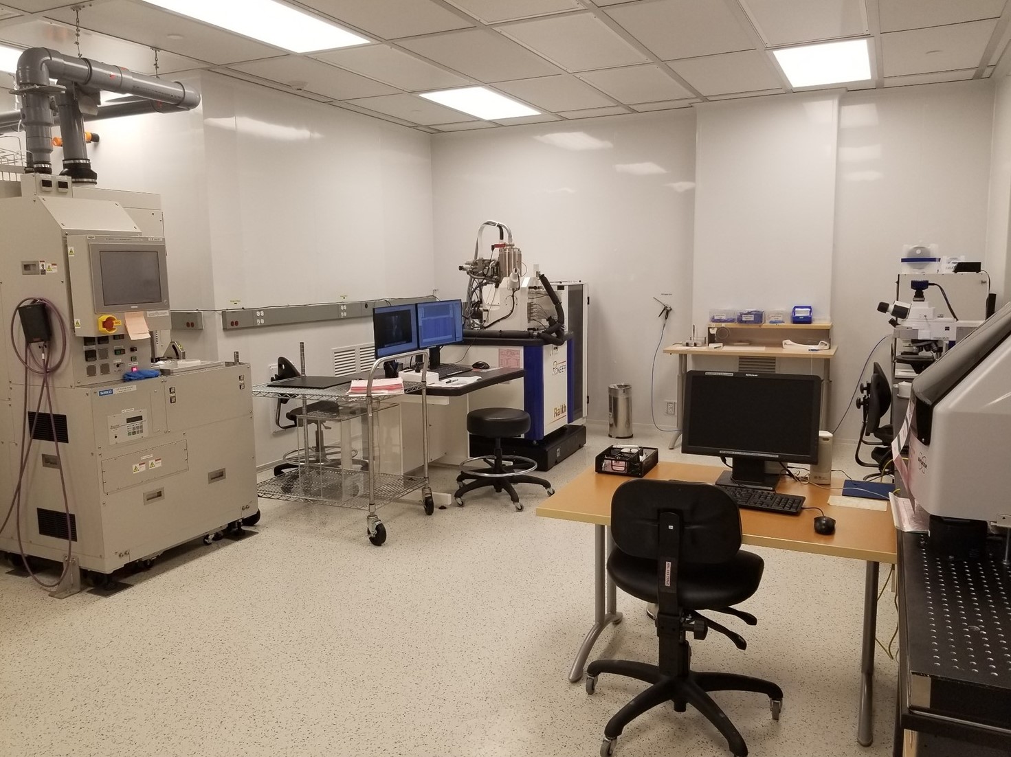 Des bancs de laboratoire longeant deux murs et divers outils de laboratoire qui se trouvent sur ces bancs et dans les armoires ci-haut.
