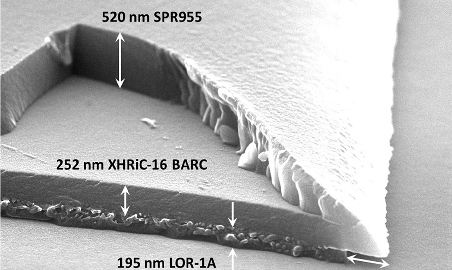 Une image d’un empilement tri-couche de photolithographie avec un morceau qui manque qui fait apparaître l’épaisseur 