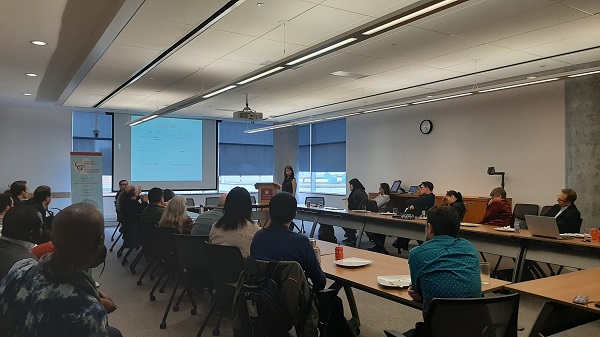 Dr. Eleonora Redaelli giving a presentation in a boardroom full of attendees