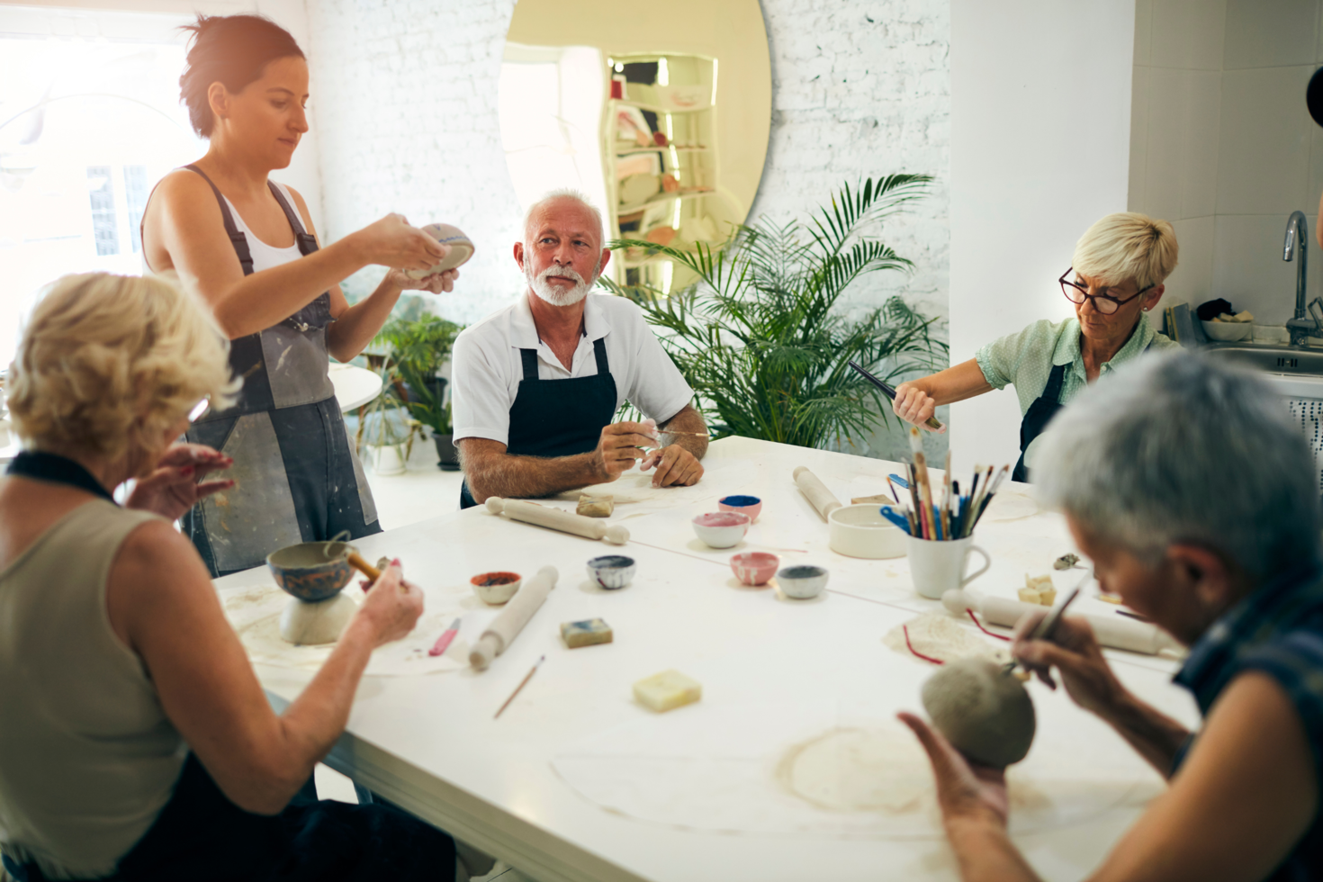 Photo de personnes en cours de poterie fabriquant des bols autour d'une table