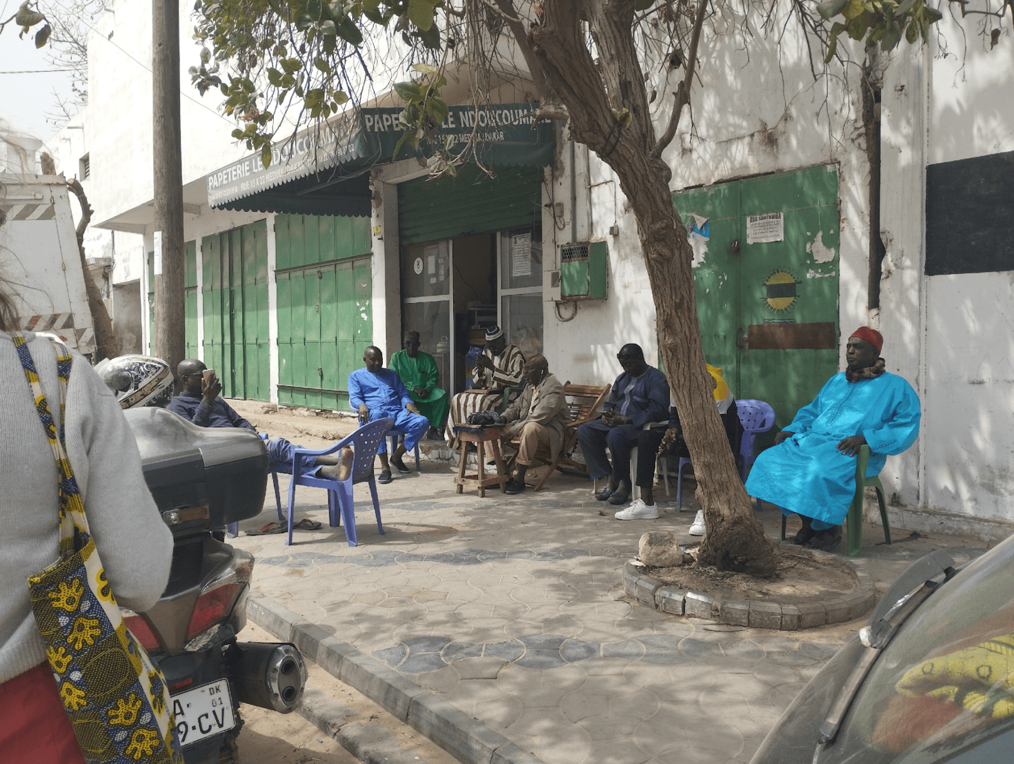 hommes assis devant une boutique