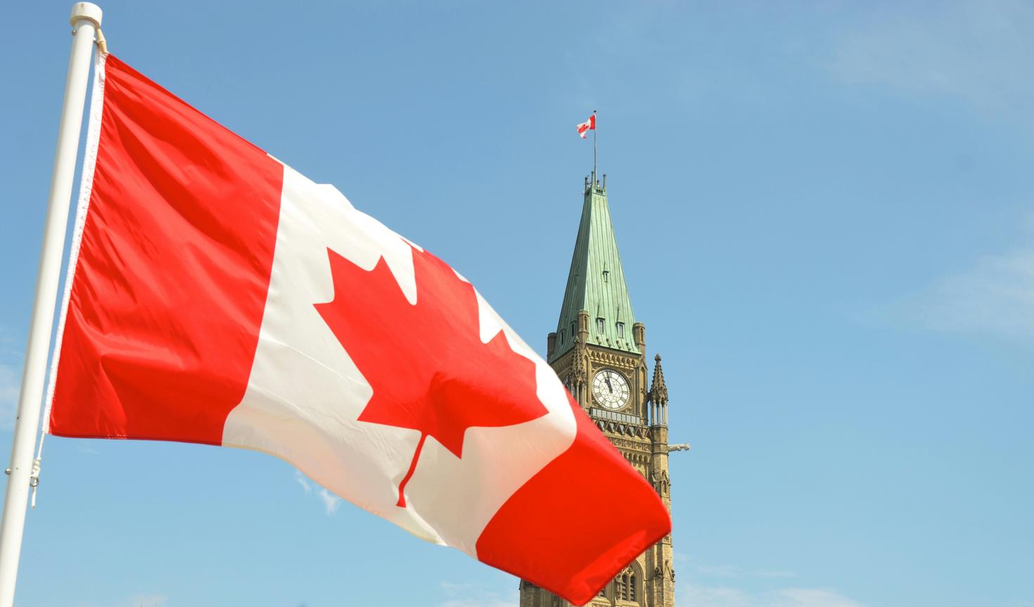 Drapeau canadien flottant devant le Parlement