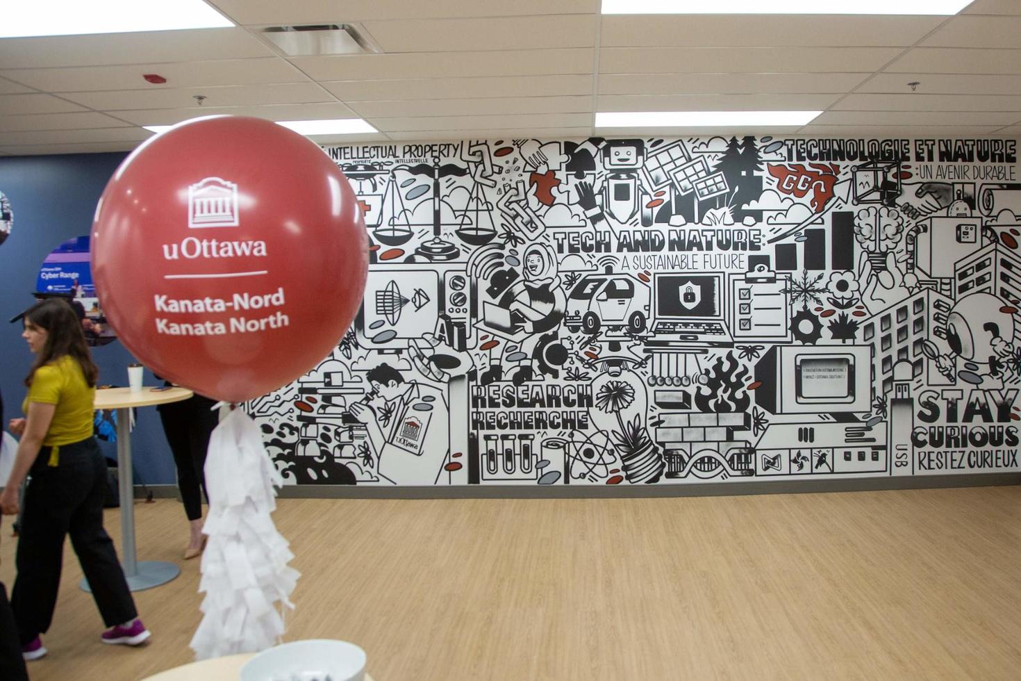 La fresque de l'uOKN avec un étudiant et avec un ballon de marque
